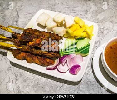 Le satay est un plat d'Asie du Sud-est composé de viande assaisonnée, brochetée et grillée, servi avec une sauce aux arachides. Banque D'Images