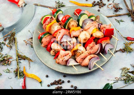 Brochettes avec morceaux de viande crue et légumes marinés dans des herbes. Banque D'Images