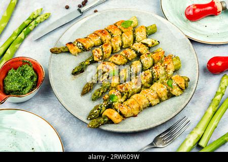 Asperges vertes végétariennes cuites dans une pâte feuilletée avec sauce pesto. Alimentation saine. Banque D'Images