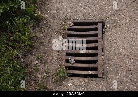 Un couvercle de drain traditionnel par Woodrow & Co et marqué du nom de la ville de Lymington Banque D'Images