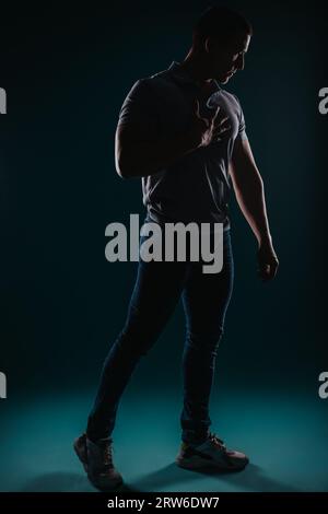 Jeune bel homme debout dans le studio et posant pour la séance photo Banque D'Images