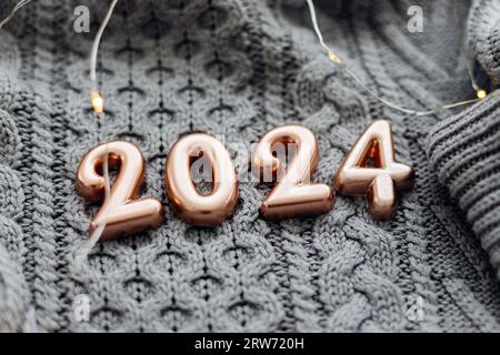 Carte postale de Noël et du nouvel an. Numéro 2024 sur fond gris tricoté. Bonne année 2024. Banque D'Images