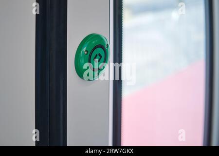 Bouton d'urgence vert sur la porte d'un train, gros plan Banque D'Images