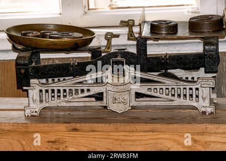 Balance en métal vintage pour un magasin avec des poids sur une table en bois. Banque D'Images