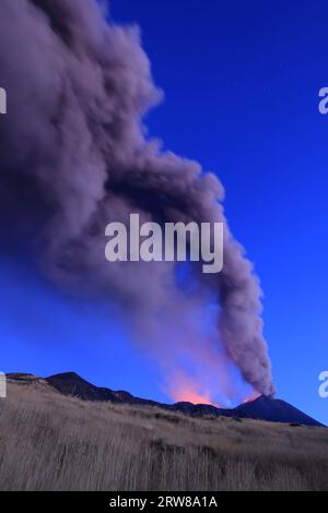 Éruption du volcan Etna vue à l’aube avec de grandes émissions de cendres du cratère avec ciel bleu en arrière-plan ; 13 août 2023 Banque D'Images