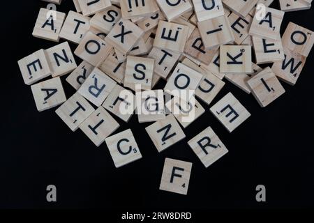 Lake Elsinore, CA, USA - 17 septembre 2023 : vue aérienne d'une pile de lettres de tuiles scrabble isolées sur noir. Banque D'Images