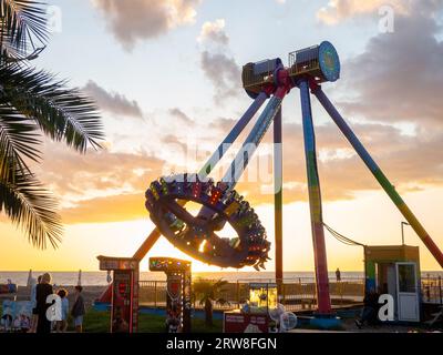 Batumi, Géorgie. 09.10.2023 silhouettes de personnes sur le carrousel. Concept de plaisir et de divertissement. Les gens sur les carrousels au coucher du soleil. Station balnéaire. Lunap Banque D'Images