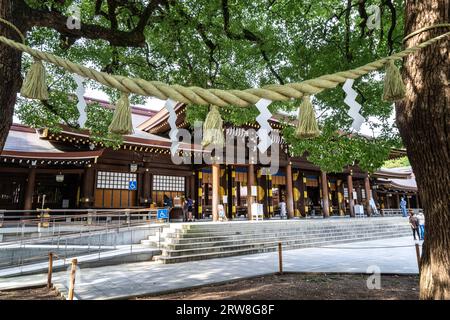 Une corde sacrée tendue entre deux camphres au Meotogusu dans la cour intérieure regardant vers le bâtiment principal du sanctuaire Meiji Jingu situé à l'intérieur d'un parc forestier de 170 hectares, à Shibuya, Tokyo, Japon. Le sanctuaire shinto est dédié aux esprits de l'empereur Meiji et de son épouse, l'impératrice Shoken. Banque D'Images