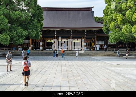 Les gens à l'intérieur de la cour intérieure regardant vers le bâtiment principal du sanctuaire Meiji Jingu situé dans un parc forestier de 170 hectares, à Shibuya, Tokyo, Japon. Le sanctuaire shinto est dédié aux esprits de l'empereur Meiji et de son épouse, l'impératrice Shoken. Banque D'Images