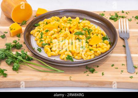 Macaroni à la courge musquée et fromage de saison d'automne plaqué sur une planche à découper Banque D'Images