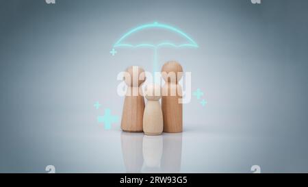 Le concept d'assurance maladie et de bien-être médical. Une famille de poupées en bois avec un parapluie et un signe plus sur fond blanc représente protec Banque D'Images
