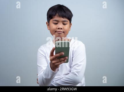 Médias sociaux et concepts technologiques. Mains d'un garçon tenant un smartphone et un crayon stylet pour utiliser le multimédia et les médias sociaux pour communiquer. Banque D'Images