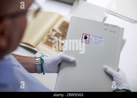 Halle, Allemagne. 05 septembre 2023. Jürgen Gröschl, un employé des fondations Francke à Halle, prépare des fonds endommagés à partir des archives Danish-Hall pour la restauration. La mission Danish-English-Halle (Tranquebar Mission) a été active dans le sud-est de l'Inde entre 1706 et 1845. Les fonds d'archives de la mission sont en très mauvais état de conservation et seront remis à un atelier de restauration dans les prochaines semaines. (À dpa-KORR : 'les archives historiques des missionnaires allemands de l'Inde seront restaurées') crédit : Jan Woitas/dpa/Alamy Live News Banque D'Images