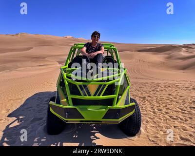 Balade en buggy dune dans le désert de Huacachine. Femme aînée assise sur un quad Banque D'Images