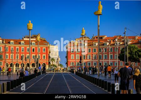 Nice, France - 29 mai 2023 : les touristes visitent la place Masséna principal monument commercial et culturel avec des bâtiments colorés ornés et la Fontaine du Soleil Banque D'Images