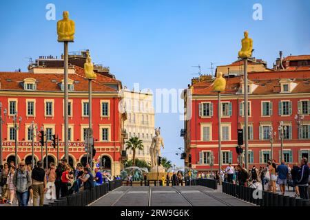 Nice, France - 29 mai 2023 : les touristes visitent la place Masséna principal monument commercial et culturel avec des bâtiments colorés ornés et la Fontaine du Soleil Banque D'Images