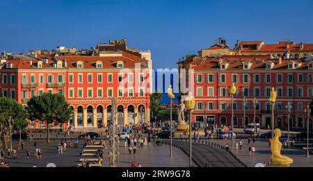 Nice, France - 29 mai 2023 : les touristes visitent la place Masséna principal monument commercial et culturel avec des bâtiments colorés ornés et la Fontaine du Soleil Banque D'Images