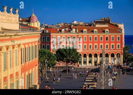 Nice, France - 29 mai 2023 : les touristes visitent la place Masséna principal monument commercial et culturel avec des bâtiments colorés ornés et la Fontaine du Soleil Banque D'Images