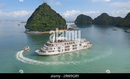 Vue aérienne de l'île Ti Top (Đảo Ti Tốp), paysage de la baie d'Halong, bateau de croisière touristique Ha long ancré près de la plage, navette d'eau turquoise tendre Banque D'Images