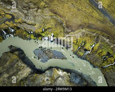 Un paysage pittoresque avec deux routes sinueuses dans un vaste espace ouvert, entouré d'une végétation luxuriante et d'une rivière tranquille qui le traverse Banque D'Images