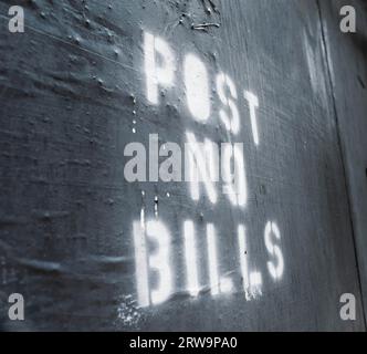 Words Post No Bills pulvérisé sur un vieux mur Banque D'Images