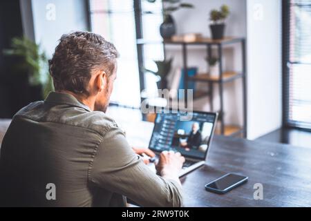 Travailleur dévoué d'âge moyen dans l'environnement de bureau, programmeur qualifié, profondément absorbé dans le programme d'écriture. Il élabore méticuleusement des lignes de code, d'expertise et de professionnalisme dans le domaine du développement logiciel. Photo de haute qualité Banque D'Images