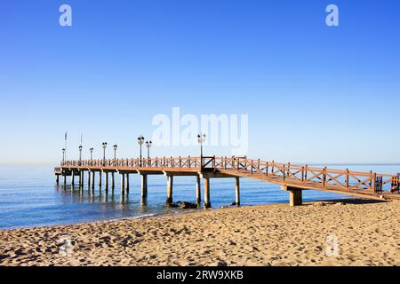 Plage de sable et une jetée en bois sur la Costa del sol entre la station balnéaire de Marbella et Puerto Banus en Espagne, province de Malaga Banque D'Images