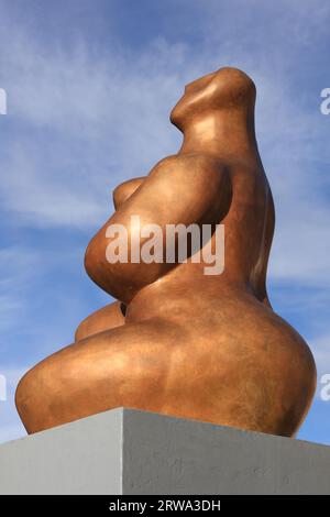 Sculpture cubiste d'une femme sur un socle gris à Sarrebourg, Lorraine, France, vue de côté, fond bleu-blanc ciel Banque D'Images