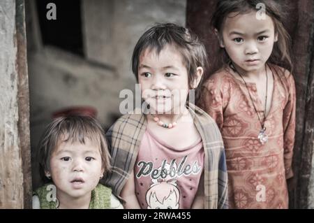 Beni, Népal, vers mai 2012 : trois petites sœurs aux cheveux bruns et aux yeux bruns posent devant une photo-caméra devant leur maison à Beni, Népal. Banque D'Images