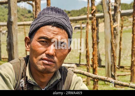 Beni, Népal, vers mai 2012 : Homme indigène avec un bonnet tricoté noir sur la tête à Beni, Népal. En arrière-plan avec construction en bois. Documentaire Banque D'Images