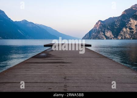 Jetée en bois sur le lac de Garde avec en toile de fond les montagnes Banque D'Images