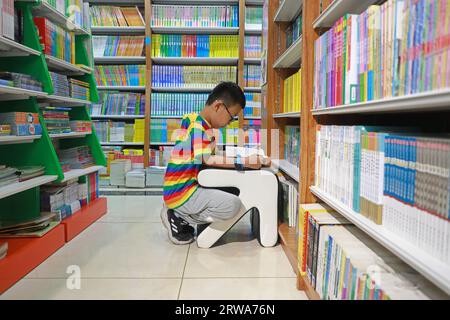 Comté de Luannan, Chine - 29 août 2019 : un enfant lit des livres dans une librairie, comté de Luannan, province du Hebei, Chine Banque D'Images