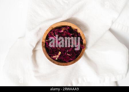 Un bol en bois naturel de pétales de rose pour les produits de soin de la peau Banque D'Images