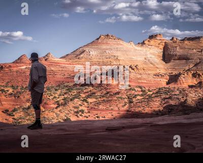 Un randonneur masculin regarde au-dessus de la vague dans Vermilion Cliffs Banque D'Images