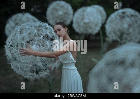 Belle ballerine avec des fleurs géantes de pissenlits Banque D'Images