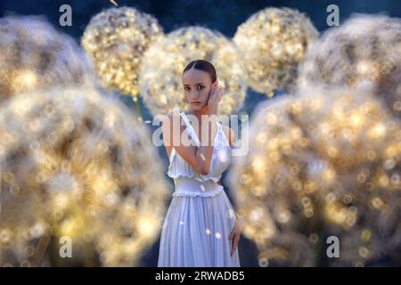 Belle ballerine avec pissenlits géants avec des lumières Banque D'Images