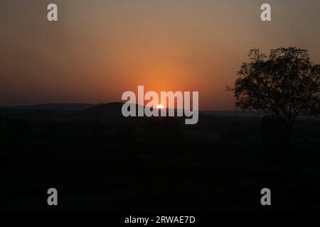 Coucher de soleil derrière la chaîne de montagnes silhourtte Banque D'Images