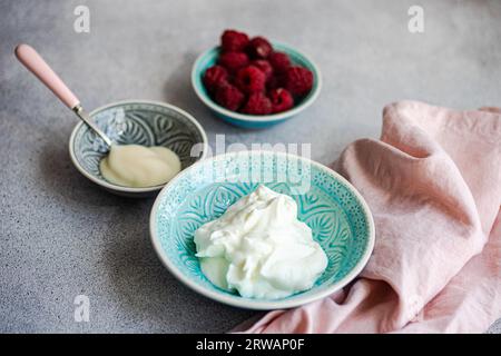 Gros plan d'un bol de yaourt avec des framboises fraîches Banque D'Images