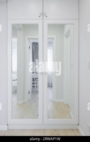 Armoire en bois blanc avec un miroir à l'intérieur du couloir Banque D'Images