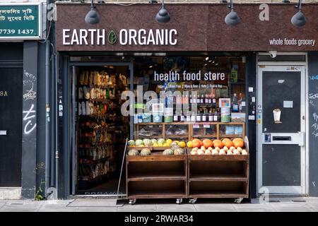 Scène de rue dans l'East End business le long de Bethnal Green Road où de nombreuses petites entreprises et boutiques indépendantes approvisionnent la région, y compris ce magasin d'alimentation biologique le 16 août 2023 à Londres, Royaume-Uni. Banque D'Images