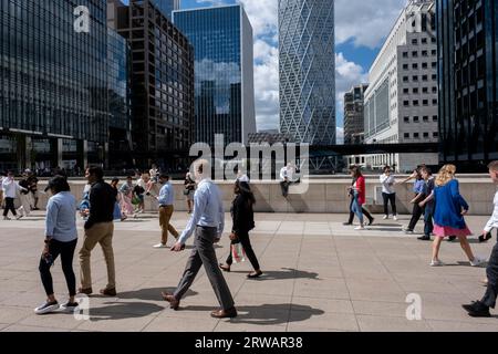 Activité à l’heure du déjeuner dans le quartier financier de Canary Wharf alors que les gens passent devant la tour Terre-Neuve qui se profile au loin le 15 août 2023 à Londres, Royaume-Uni. Canary Wharf est une zone située près de l'île des chiens dans le quartier londonien de Tower Hamlets et est définie par la Greater London Authority comme faisant partie du quartier central des affaires de Londres. Avec la City de Londres, il constitue l'un des principaux centres financiers du Royaume-Uni et du monde, abritant de nombreux immeubles de grande hauteur. Ces dernières années, et avec le changement des pratiques de travail de bureau à hybride et Banque D'Images