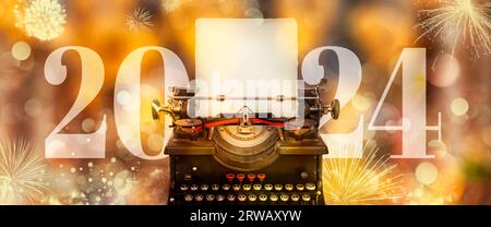 Annonce du nouvel an 2024 avec machine à écrire et fond doré défocalisé et feux d'artifice Banque D'Images