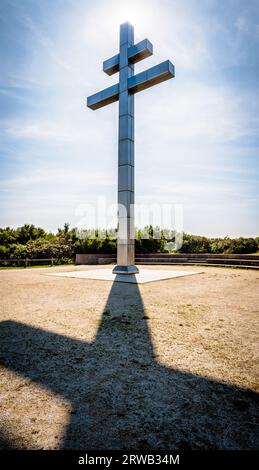 Vue rétroéclairée de la grande croix de Lorraine érigée en 1990 sur Juno Beach pour commémorer le retour du général de Gaulle en France en juin 1944. Banque D'Images