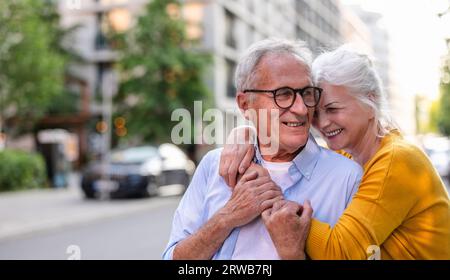 Portrait d'un couple senior heureux embrassant dans la ville Banque D'Images