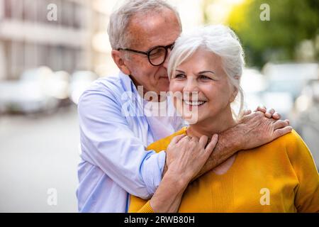 Portrait d'un couple senior heureux embrassant dans la ville Banque D'Images