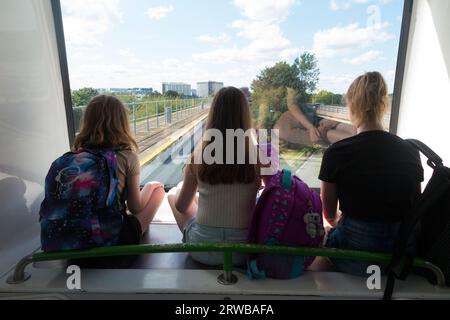 Trois sœurs, enfants, enfants, montent le service de navette inter-terminal, le train shuffle de Gatwick entre le terminal nord et les terminaux sud de l'aéroport de Gatwick, Londres, Royaume-Uni. (135) Banque D'Images