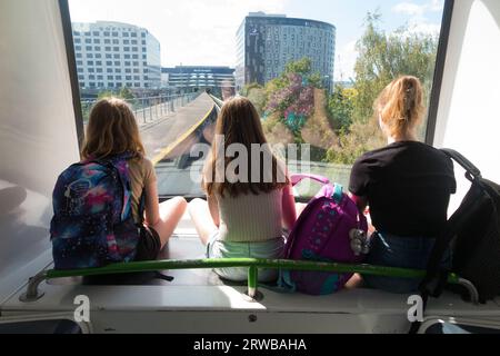 Trois sœurs, enfants, enfants, montent le service de navette inter-terminal, le train shuffle de Gatwick entre le terminal nord et les terminaux sud de l'aéroport de Gatwick, Londres, Royaume-Uni. (135) Banque D'Images