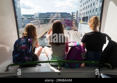 Trois sœurs, enfants, enfants, montent le service de navette inter-terminal, le train shuffle de Gatwick entre le terminal nord et les terminaux sud de l'aéroport de Gatwick, Londres, Royaume-Uni. (135) Banque D'Images