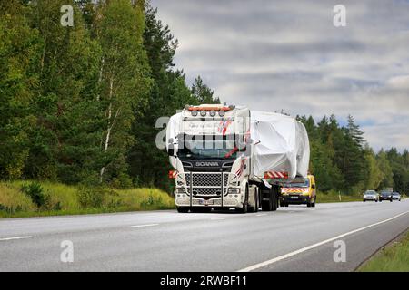 La remorque à plateau Scania R580 transporte une large charge vers le port de Hanko. Le transport a des véhicules pilotes à l'avant et à l'arrière. Raasepori, Finlande. 8 septembre 23 Banque D'Images