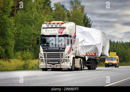 La remorque à plateau Scania R580 transporte une large charge vers le port de Hanko. Le transport a des véhicules pilotes à l'avant et à l'arrière. Raasepori, Finlande. 8 septembre 23 Banque D'Images